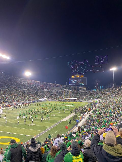 A drone light show drawing the Oregon Duck in the night sky over Autzen Stadium