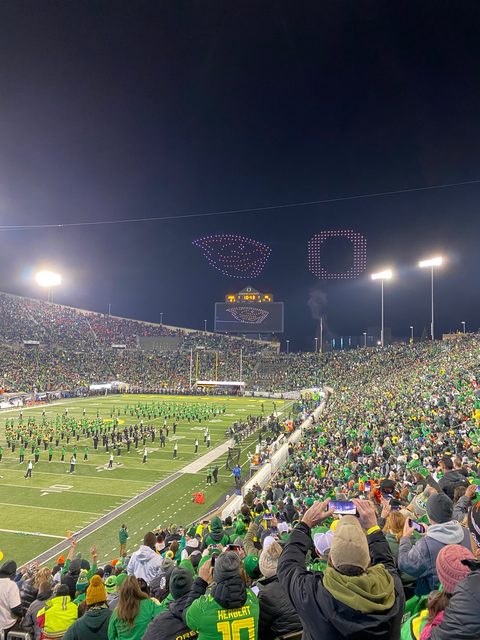 A drone light show drawing the Oregon O in the night sky over Autzen Stadium