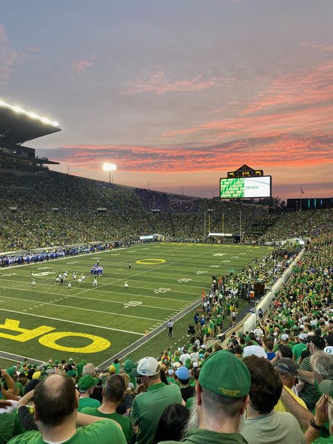Autzen Stadium at sunset with a pink sky and GET LOUD on the scoreboard